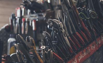 A close-up shot of pliers, wrenches, and other tools, all a bit greasy and clearly well-used.