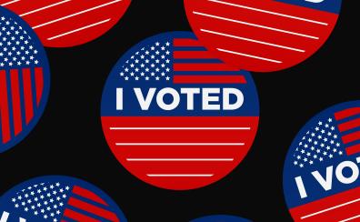 Red white and blue "I Voted" stickers on a black background 