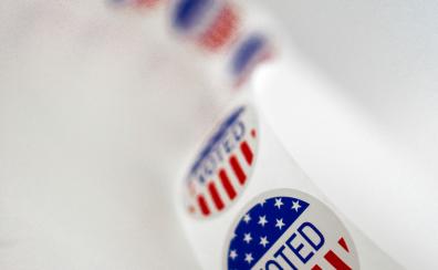 Red, white, and blue roll of "I Voted" stickers on a white background 