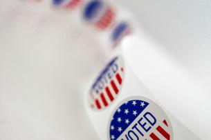 Red, white, and blue roll of "I Voted" stickers on a white background 