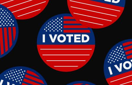 Red white and blue "I Voted" stickers on a black background 